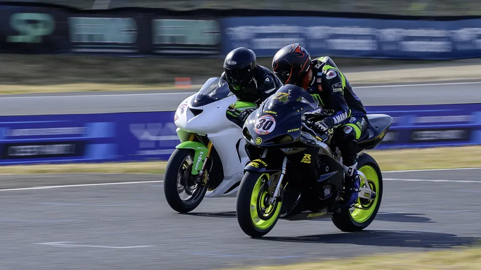 Deux pilotes moto rapprochés pendant une phase de course sur circuit
