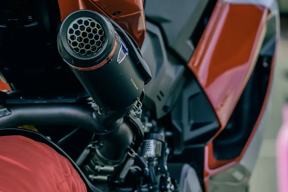 Gros plan sur un élément mécanique et l’échappement d’une moto de course