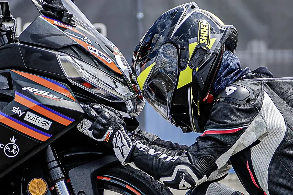 Mécanicien penché sur une moto dans le paddock