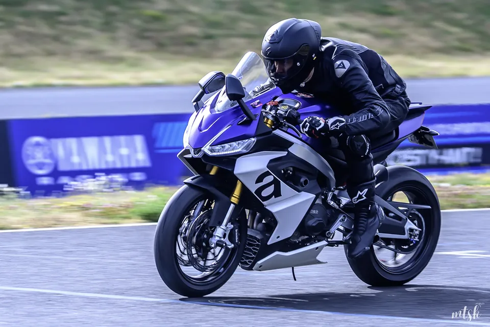 Moto bleue et blanche photographiée en appui dans un virage