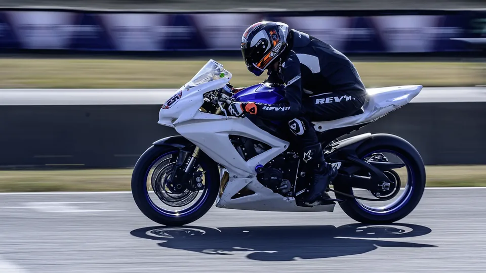 Moto de course blanche photographiée de profil sur la trajectoire