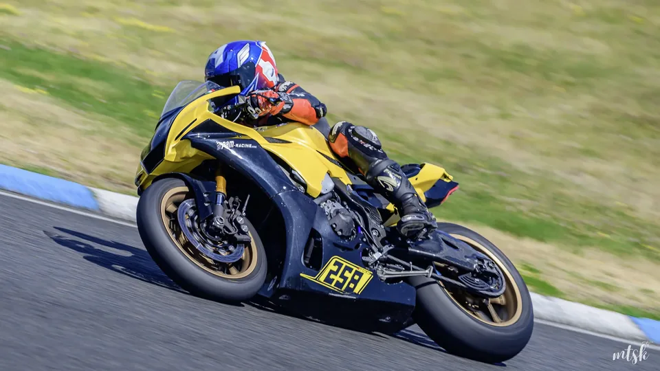 Moto noire et jaune photographiée sur l’angle dans une lumière rasante