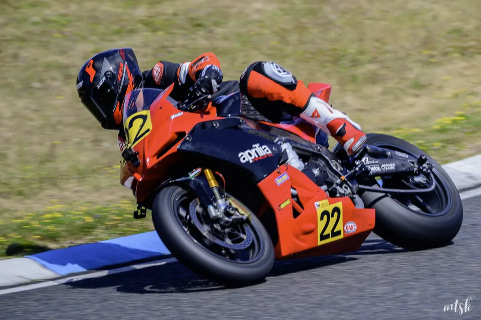 Moto orange photographiée très inclinée au passage d’un vibreur