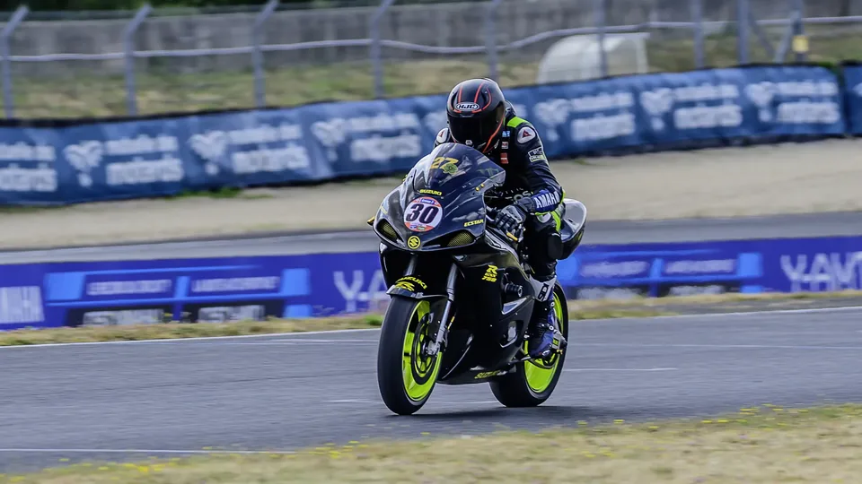 Moto verte photographiée de face pendant une accélération sur circuit