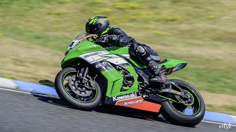 Moto verte et noire sur une trajectoire serrée près du vibreur