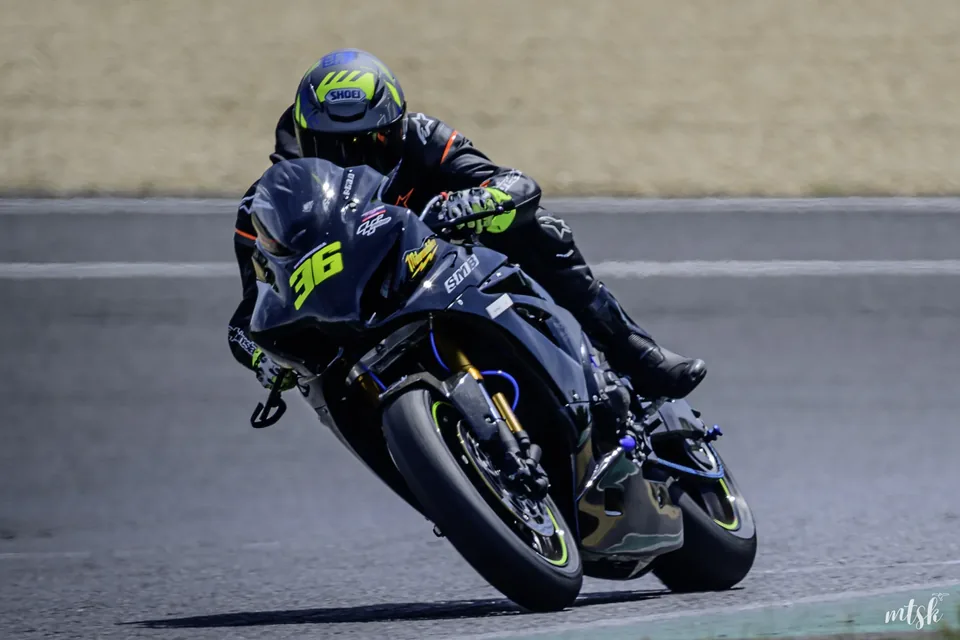 Pilote moto en tenue sombre en virage