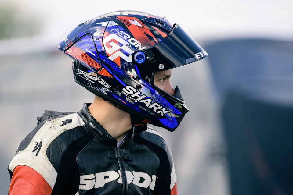 Portrait de profil d’un pilote moto portant son casque et sa combinaison