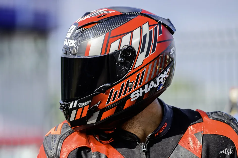 Portrait serré d’un pilote portant un casque orange et noir